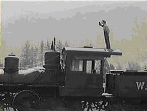 Film still of Buster Keaton standing atop a steam locomotive.