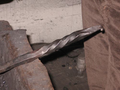 A square bar is hammered into an octagonal shape, twisted, and then hammered a bit more.