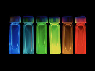 small, semi-transparent vials ranging in color from red to orange, yellow, green, and blue.
