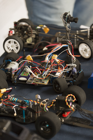 Set of three small robotic cars showing interior and wiring.