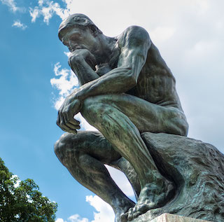 Statue "The Thinker" of a man with his head on his chin. 